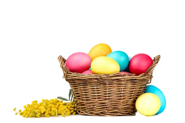 Easter eggs in basket with flowers isolated on white background — Stock Photo, Image