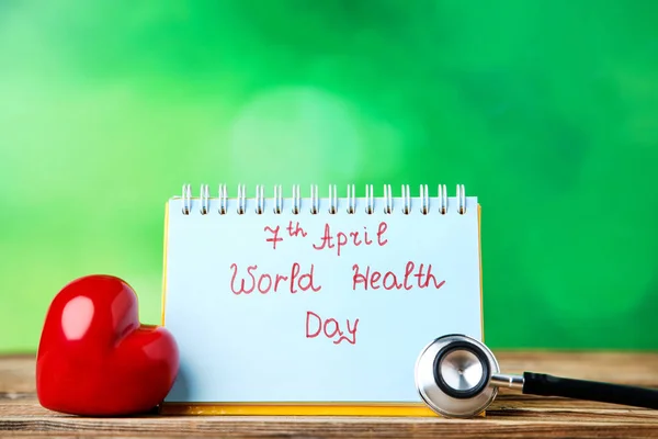 Texto Día Mundial de la Salud con estetoscopio y corazón rojo en ba verde —  Fotos de Stock