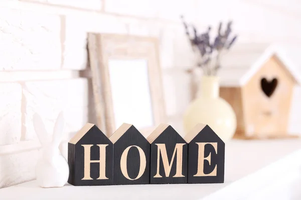 Word Home with ceramic rabbit on white fireplace — Stock Photo, Image