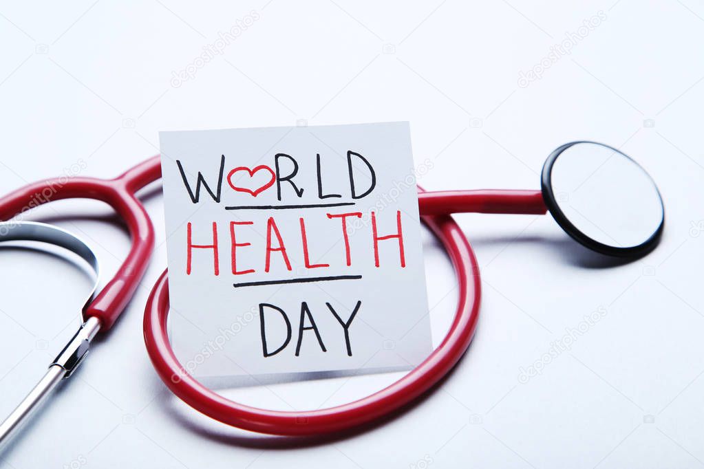 Text World Health Day with stethoscope on grey background