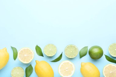 Olgun limon ve limes yeşil yapraklar üzerinde mavi arka plan