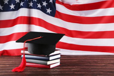 Kitap yığını ve kahverengi Woo üzerinde Ingiliz bayrağı ile mezuniyet kapağı