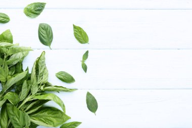 Ahşap masada yeşil fesleğen yaprakları