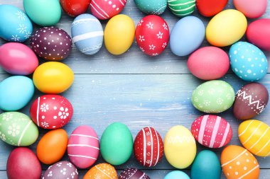 Mavi ahşap masada renkli Paskalya yumurtası