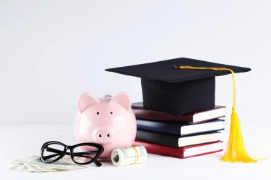 Servet mezuniyet kap, kitap, gözlük ve Doları banknot ile