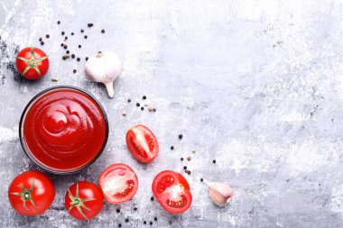 Gri ahşap masada pepepr ve sarımsak ile kase ketçap