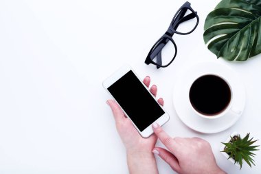 Kahve, gözlük ve yeşil bir fincan ile kadın elleri Smartphone