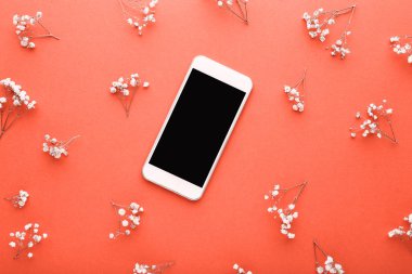 Turuncu arka planda küçük beyaz çiçekler ile Smartphone