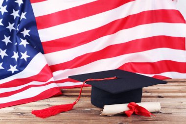 Diploma ve kahverengi ahşap ta Amerikan bayrağı ile mezuniyet kap