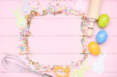 Paskalya yumurtası, mutfak eşyaları ve renkli serpin ile tavşan