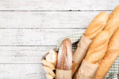 Taze baget ekmek sepeti ahşap masa üzerinde peçete ile