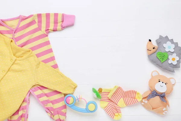 Bayi pakaian dengan mainan lembut di latar belakang putih — Stok Foto