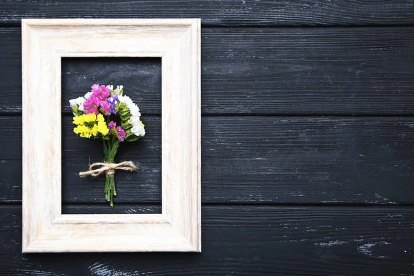 Fiori primaverili con cornice su tavolo in legno nero — Foto Stock