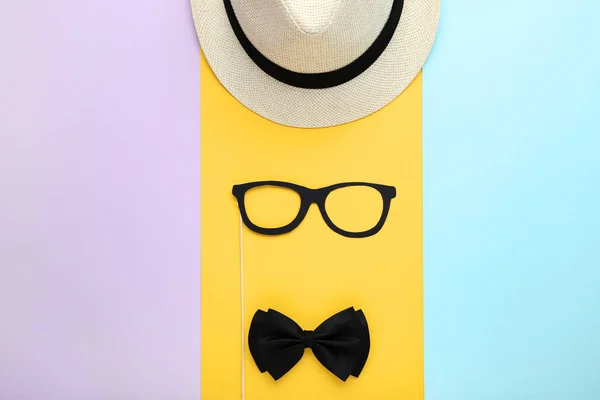 Papieren bril met strikje en muts op kleurrijke achtergrond — Stockfoto