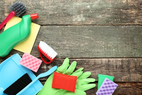 Botella con detergente y herramientas de limpieza sobre mesa de madera gris —  Fotos de Stock