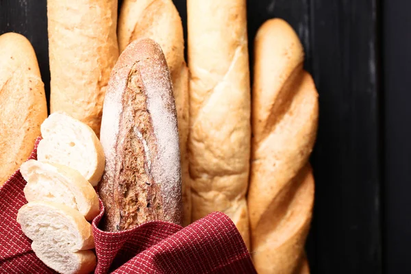 Baguettes frescos con servilleta roja sobre mesa de madera negra — Foto de Stock