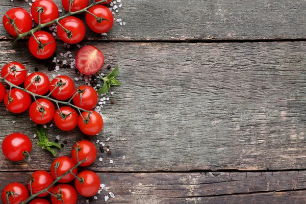 Tomat ceri dengan daun kemangi dan rempah-rempah di atas meja kayu abu-abu — Stok Foto
