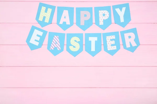 Texto Feliz Pascua en mesa de madera rosa — Foto de Stock