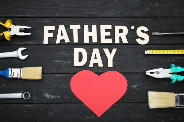 Opschrift Fathers Day met verschillende tools op zwarte houten tab — Stockfoto