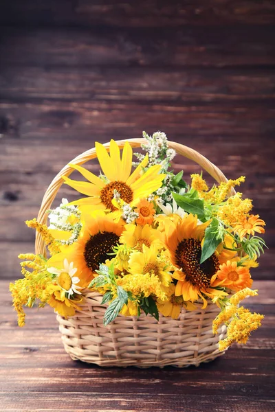 Spring flowers in basket on brown wooden table — Stock Photo, Image