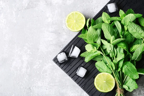 Mint leafs dengan limau dan es batu di meja kayu abu-abu — Stok Foto