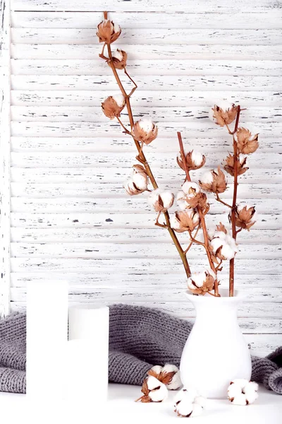 Pamut virágok vázában gyertyákkal és szürke sállal — Stock Fotó