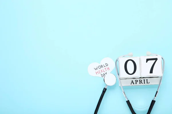 Texto Día Mundial de la Salud con estetoscopio y calendario cubo en azul —  Fotos de Stock