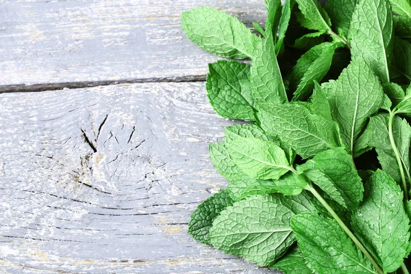 Mint leafs on grey wooden table — Stock Photo, Image