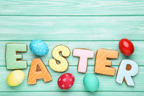 Colorful eggs with word Easter on wooden table — Stock Photo, Image