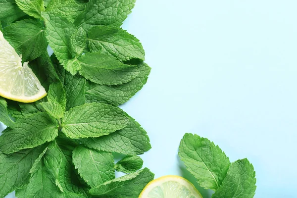 Hojas de menta con rodajas de limón sobre fondo azul — Foto de Stock