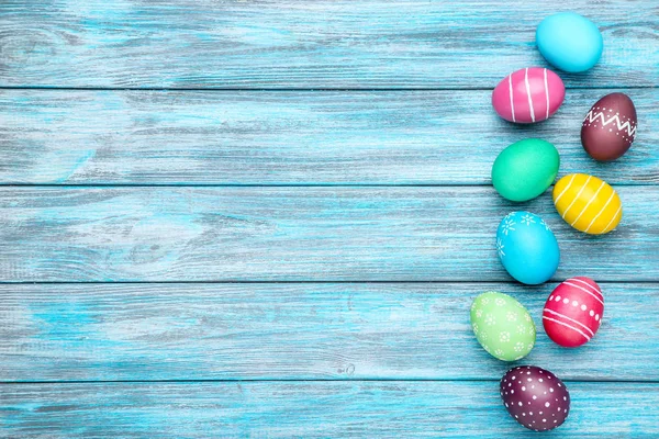 Huevos de Pascua coloridos en mesa de madera azul — Foto de Stock