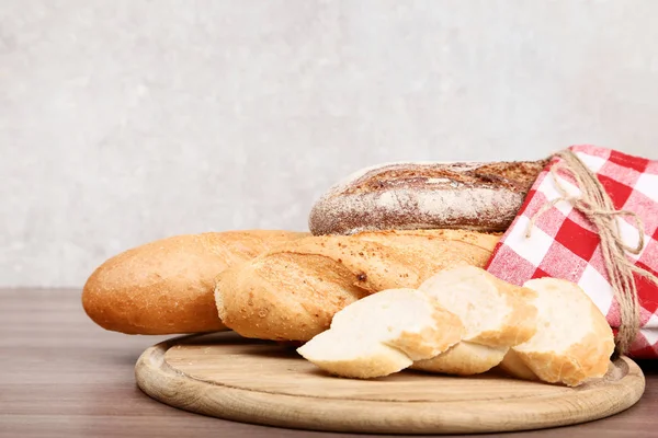 Baguettes frescos con servilleta roja sobre mesa de madera — Foto de Stock