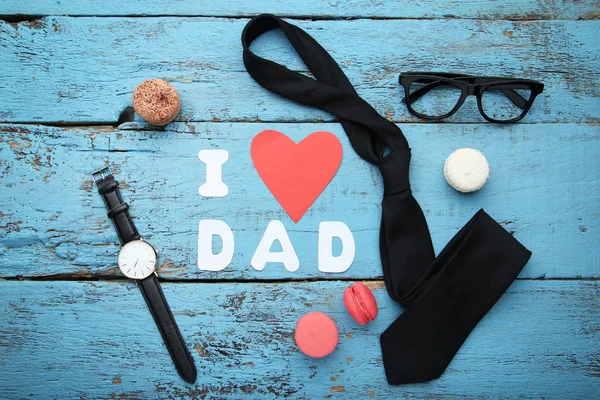 Inscription I Love Dad with macarons and accessories on blue woo