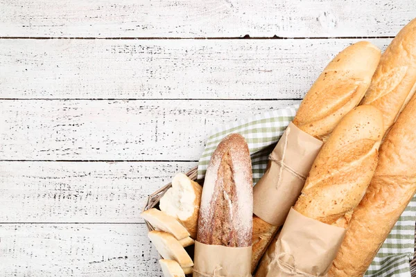 Taze baget ekmek sepeti ahşap masa üzerinde peçete ile — Stok fotoğraf
