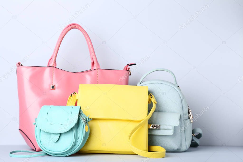 Fashion handbags and backpack on grey background