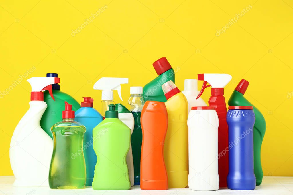 Bottles with detergent on yellow background