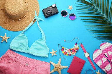 Palmiye yaprağı ve aksesuarları üzerinde mavi arka plan ile mayo