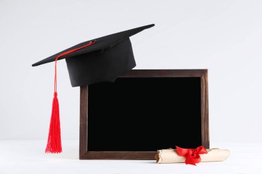 Boş çerçeve ve gri arka plan üzerine diploma ile mezun kap