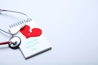 Metin Dünya Sağlık günü gri arka plan üzerinde stetoskop ve kırmızı kalpli