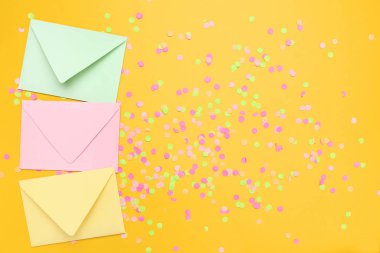 Konfeti sarı arka plan üzerinde renkli zarfları