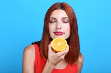 Mavi arka plan üzerinde turuncu meyve kadınla güzel redhaired