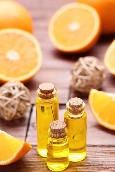 Aceite de naranja en botellas sobre mesa de madera marrón —  Fotos de Stock