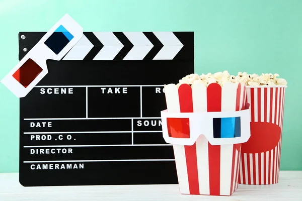 Tablero Clapper con palomitas de maíz y vasos sobre fondo de menta —  Fotos de Stock