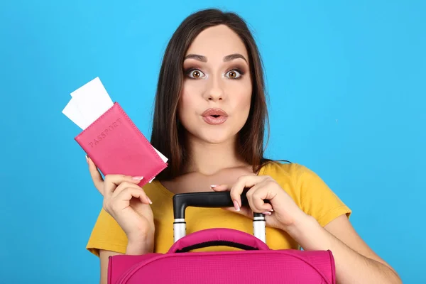 Giovane ragazza con valigia e passaporto su sfondo blu — Foto Stock