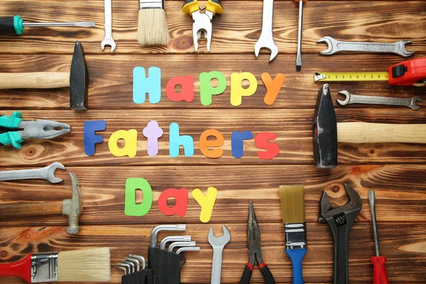 Opschrift Fathers Day met verschillende tools op bruin houten tabblad — Stockfoto