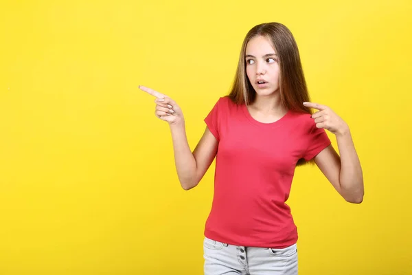 Ung flicka iklädd t-shirt på gul bakgrund — Stockfoto