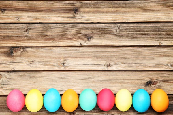 Huevos de Pascua coloridos en mesa de madera marrón —  Fotos de Stock