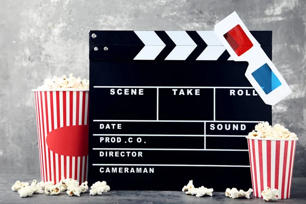 FILMKLAPPA med popcorn och glasögon på grå träbord — Stockfoto