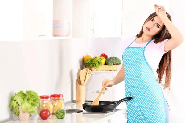 Giovane donna stanca che cucina la cena in cucina — Foto Stock