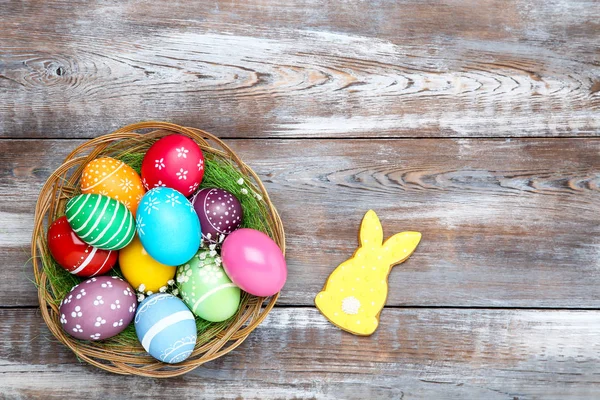 Coloridos huevos de Pascua en cesta con flores de gypsophila y jengibre — Foto de Stock